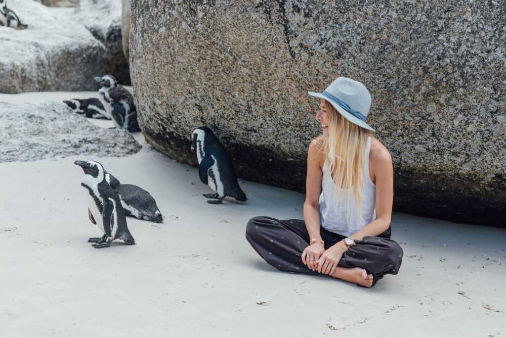 woman-with-penguins-sitting-beach