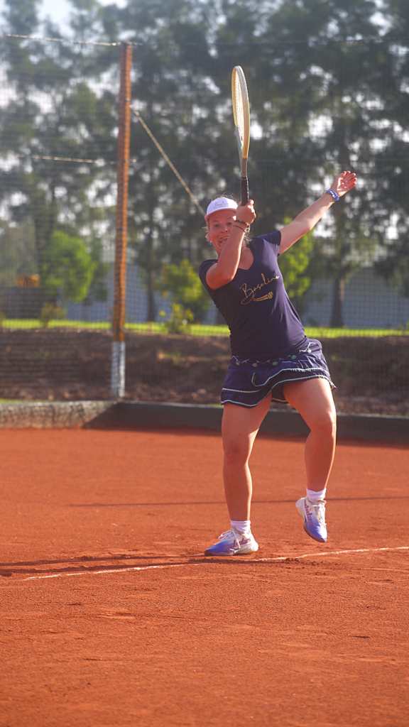 A player hitting a tennis shot on the clay court at Portland Manor during Courts of the Forest.