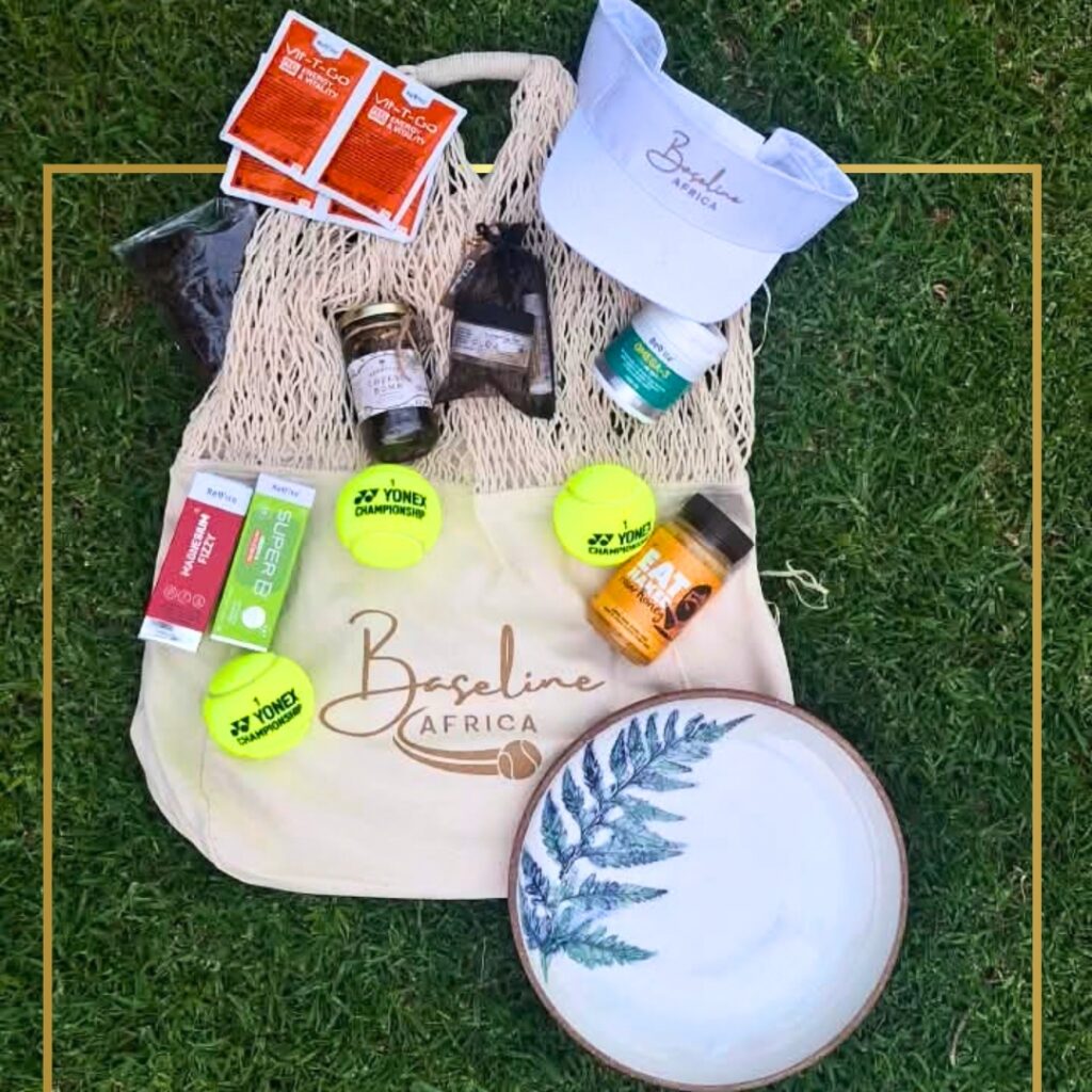Courts of the Forest goodie bag contents on the grass, including a Baseline Africa visor and a leaf-decorated ceramic plate by Christiaan Snyman